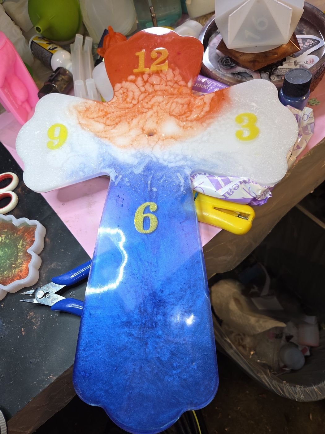 Cross-shaped resin clock in red, white, and blue with gold numbers