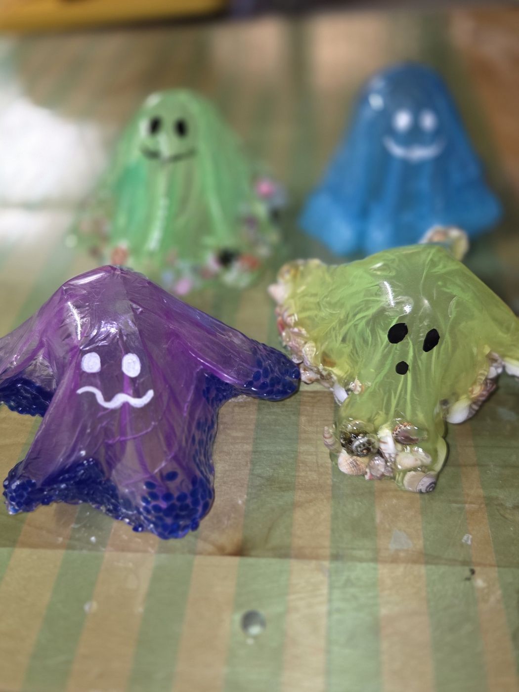 Translucent resin ghosts in purple, green, blue, and lime